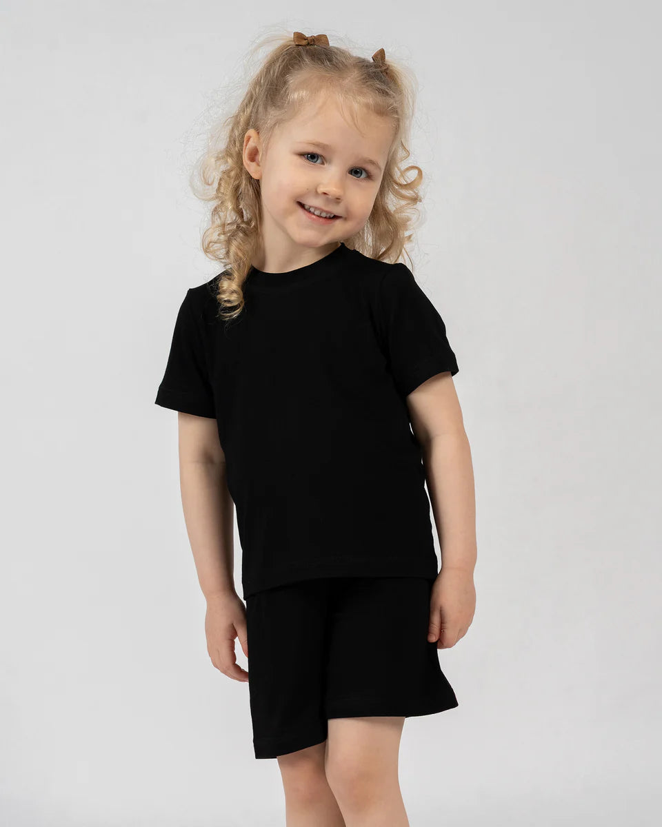 Young girl wearing a black outfit against a white background