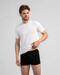 Man wearing a white t-shirt and black underwear on a gray background