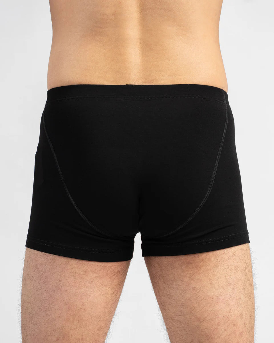 Black boxer briefs worn by a person on a light gray background