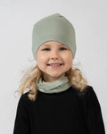 Child wearing a green beanie and scarf on a white background