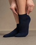 Person wearing navy blue socks on a beige background