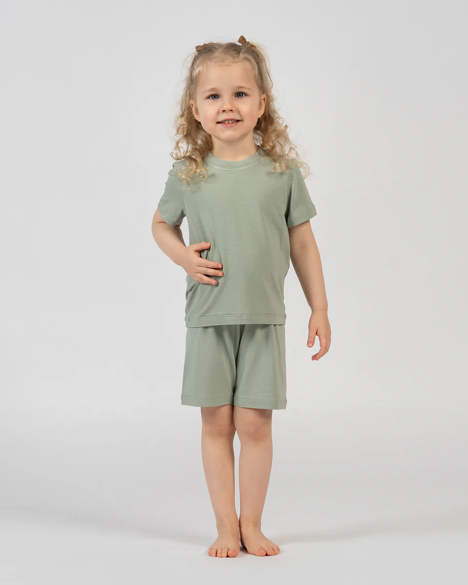 Child wearing a green outfit on a white background