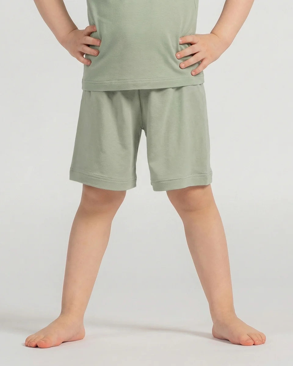 Person wearing green shorts and a matching top on a plain background