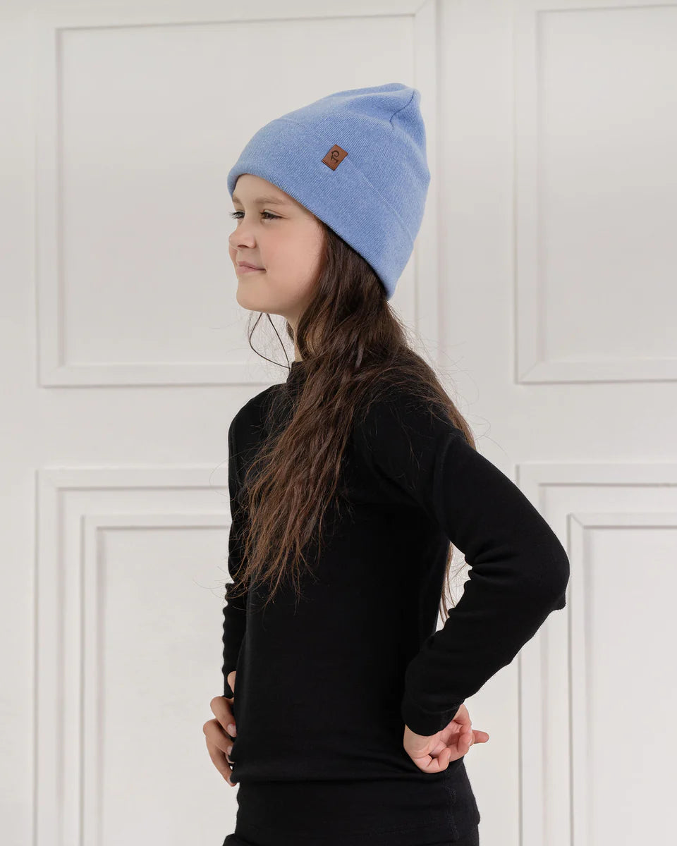 Child wearing a light blue knitted merino-cashmere beanie with brand logo