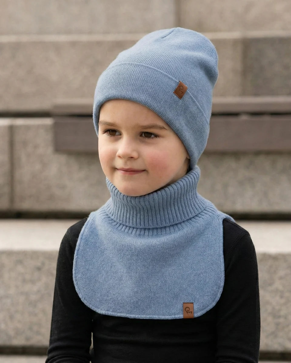 Child wearing a blue knitted cashmere dickie bib