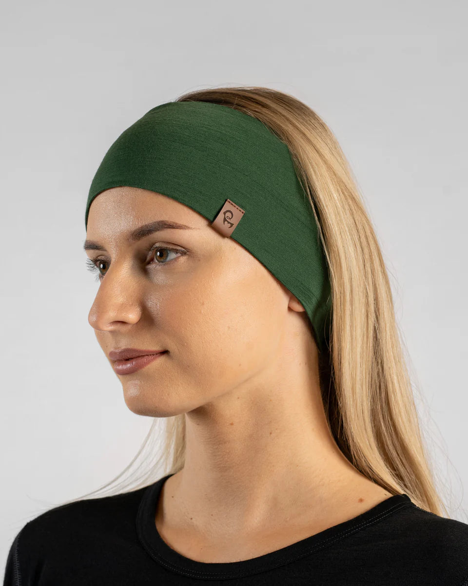 Woman wearing a green headband with a brand logo on a light gray background