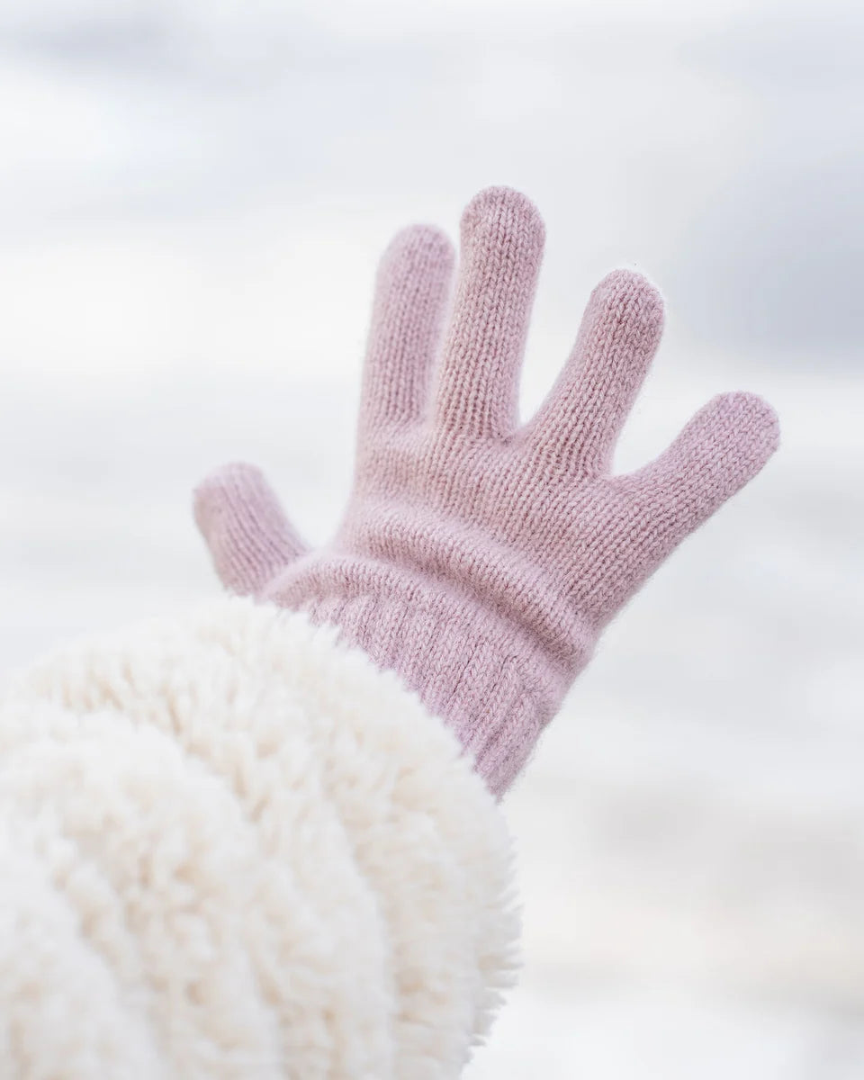 Pink knitted glove on a white background