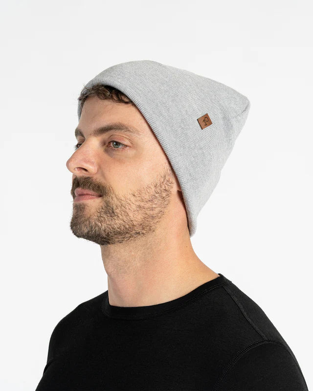 Man wearing a gray beanie with a brand logo on a white background