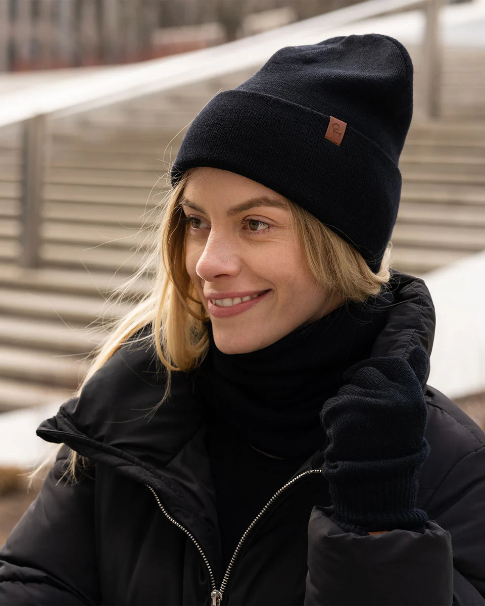 Person wearing a black beanie and coat outdoors