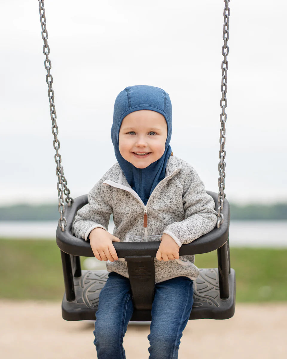 Child wearing a denim-colored merino balaclava outdoors