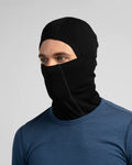 Person wearing a black balaclava over a blue shirt on a light gray background
