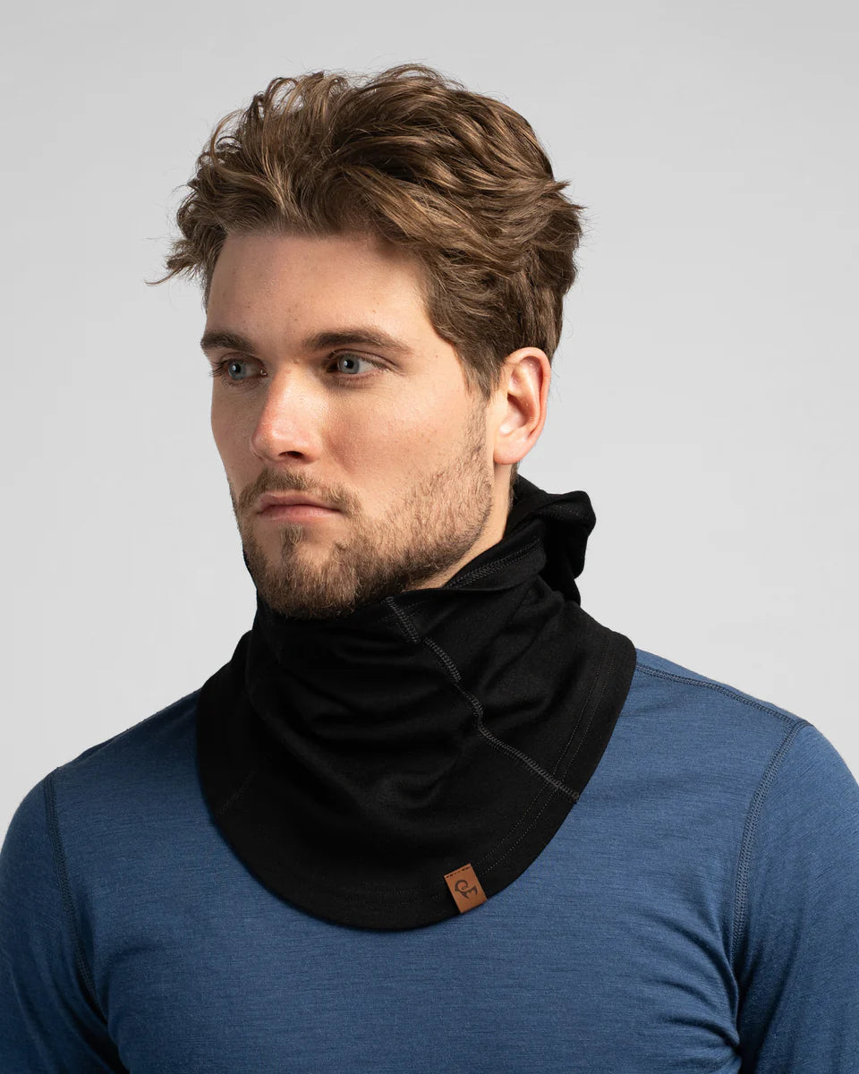Man wearing a black scarf with a blue shirt on a gray background