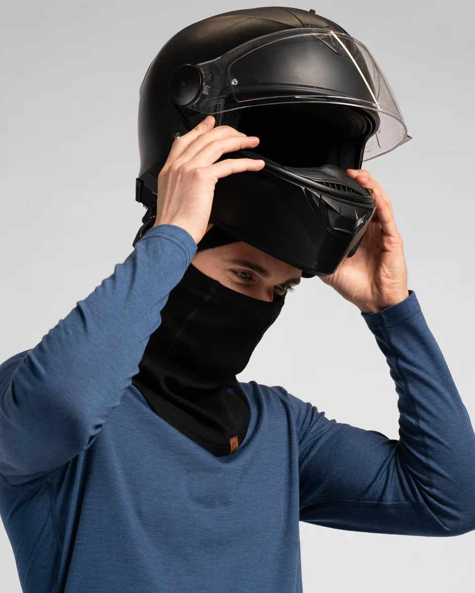 Person wearing a black helmet and blue long-sleeve shirt on a gray background