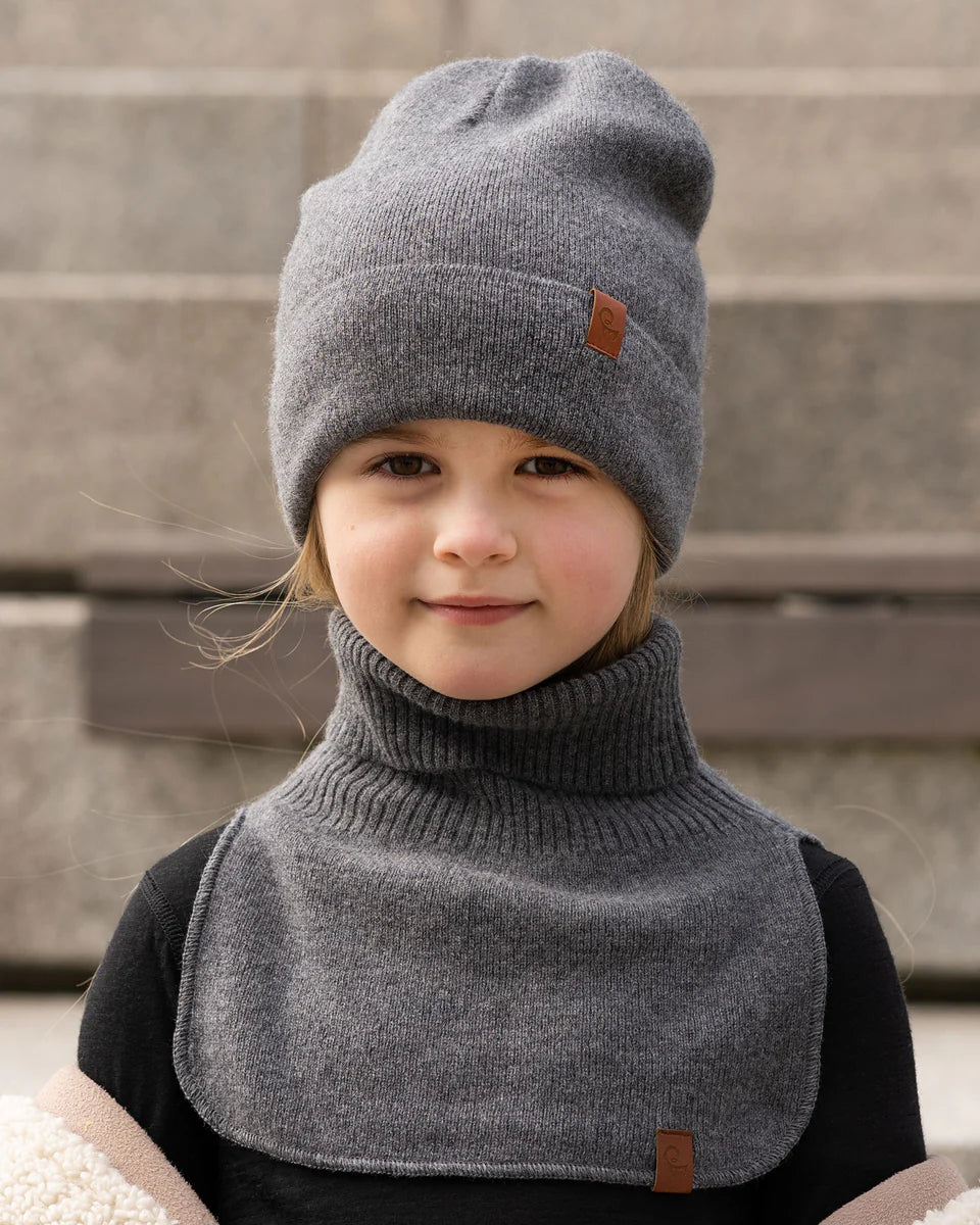 Child wearing a dark gray knitted merino dickie bib
